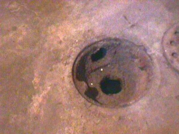 A hole in the floor of an unfinished room.