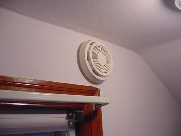 A white fan mounted to the side of a wall.